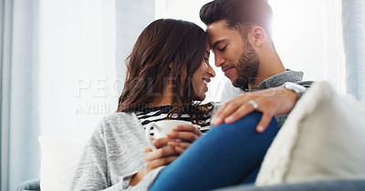 Buy stock photo Cropped shot of an affectionate young couple cuddling with each other while in their living room during the day