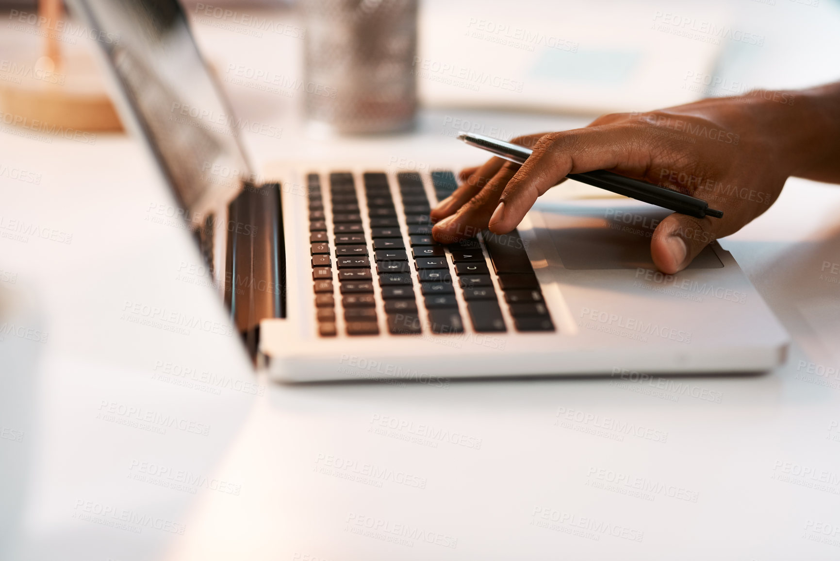 Buy stock photo Shot of an unrecognizable businessman working on his laptop during a late night shift at work