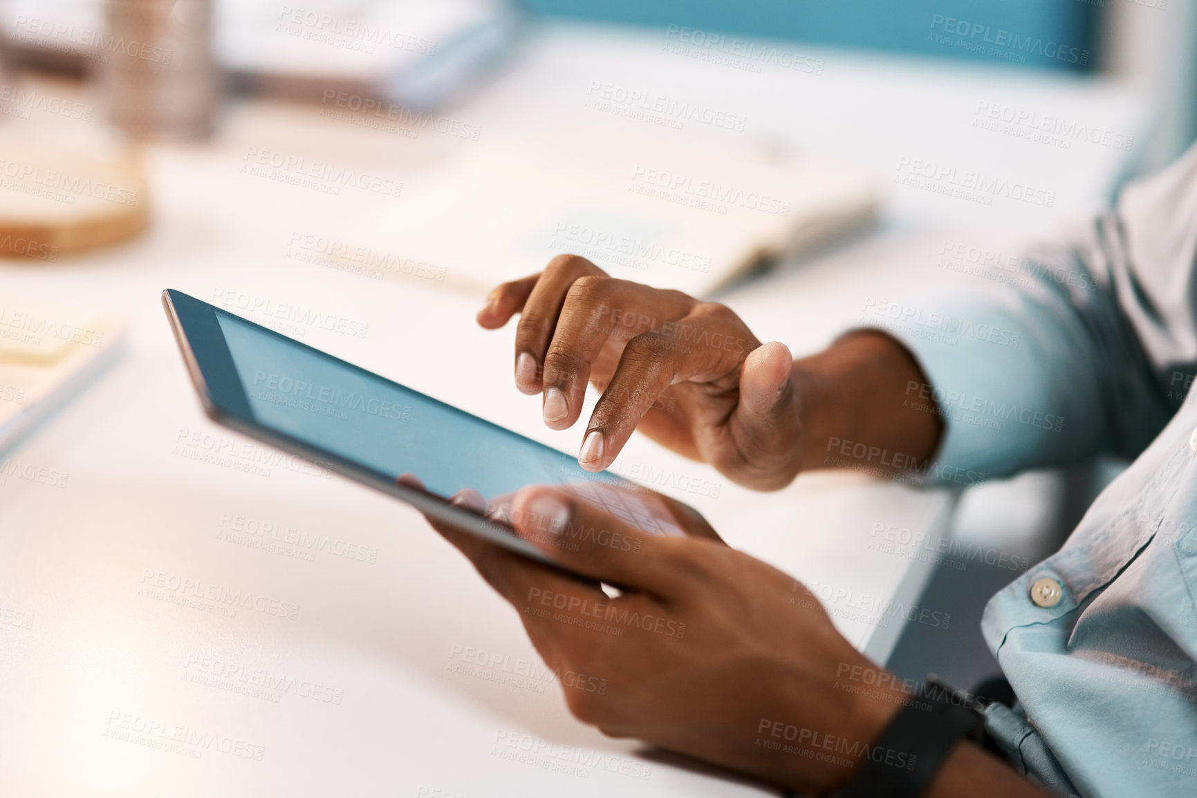 Buy stock photo Shot of an unrecognizable businessman using a digital tablet while working late in his office