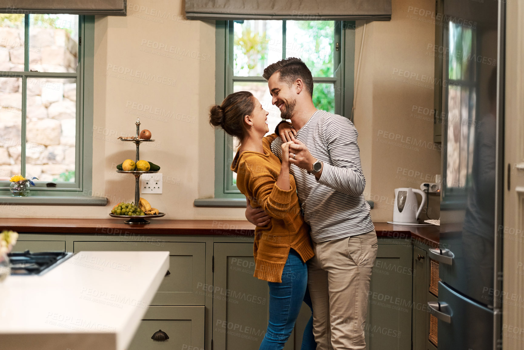 Buy stock photo Happy, couple and dance with love in kitchen for bonding, romantic connection and sweet embrace for relationship. Man, woman and together in home with rhythm for affection, care and compassion.