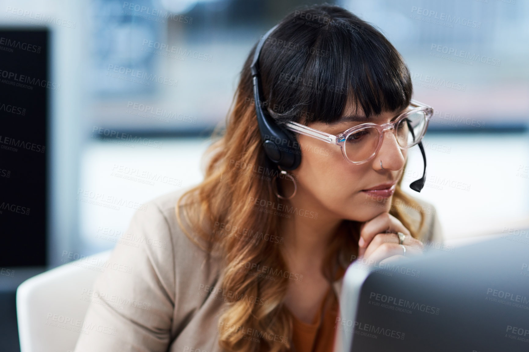 Buy stock photo Cropped shot of an attractive young businesswoman sitting and using a headset in her office during the day