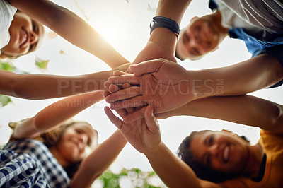 Buy stock photo Cropped shot of a happy family joining hands together in unity at the park