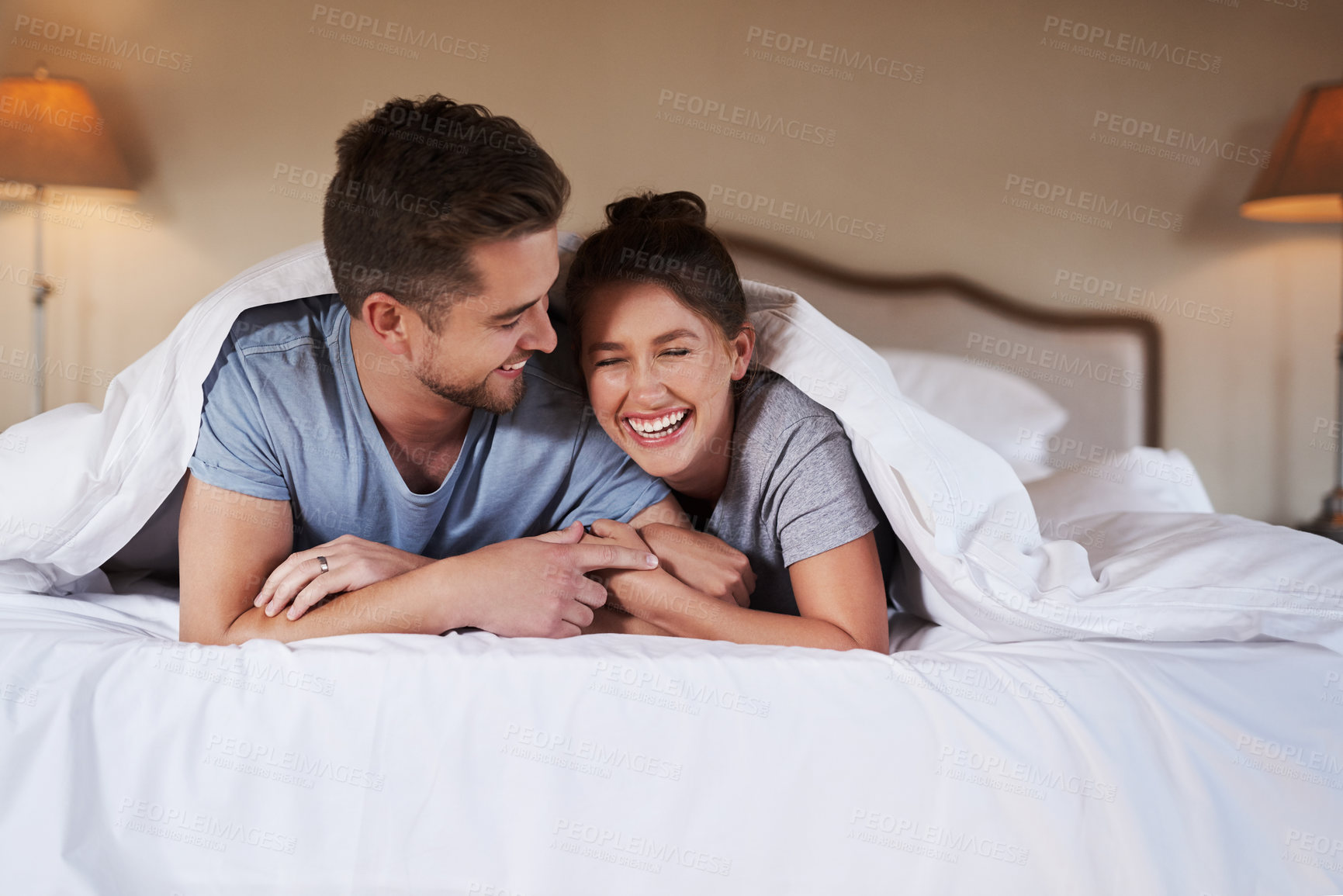 Buy stock photo Shot of an affectionate young couple spending some quality time together in their bedroom at home