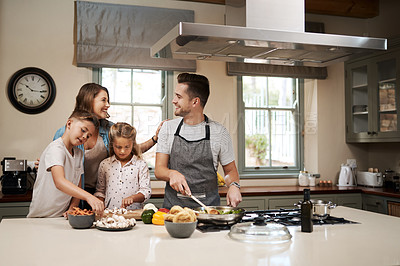 Buy stock photo Cropped shot of a young family cooking in the kitchen