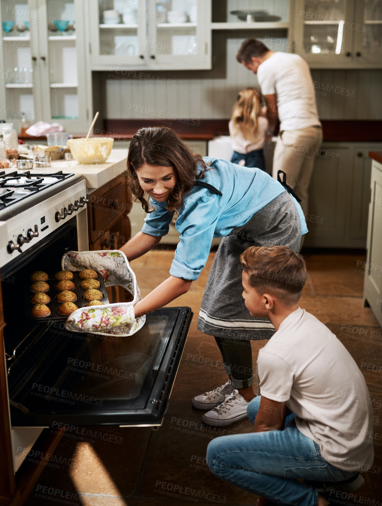Buy stock photo Shot of a young woman and her son baking muffins in the kitchen at home