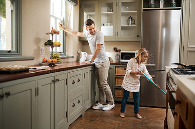 Buy stock photo Shot of a young man and his daughter cleaning the kitchen at home