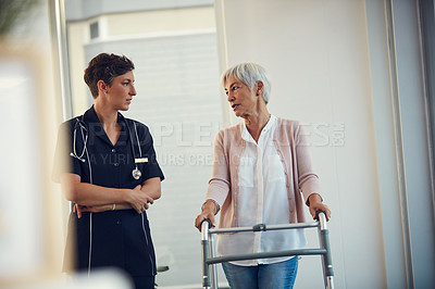 Buy stock photo Cropped shot of a senior woman having a discussion with a young female nurse while using a walker in a nursing home