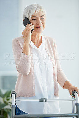 Buy stock photo Cropped shot of a happy senior woman taking a phonecall while using a walker in a retirement home