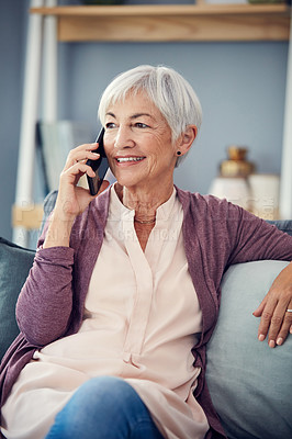 Buy stock photo Cropped shot of a happy senior woman taking a phonecall while relaxing on her couch at home