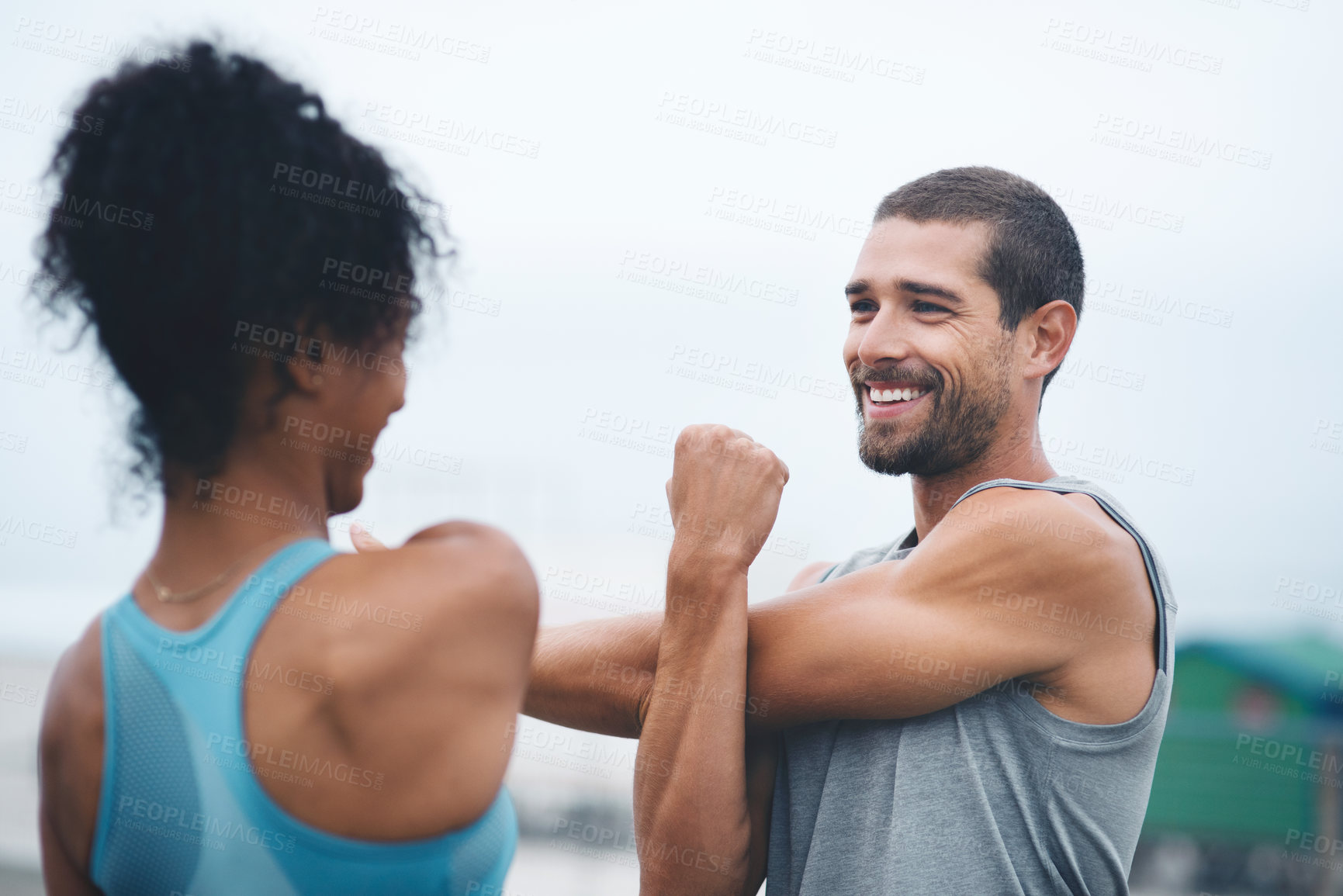 Buy stock photo Couple, outdoor and stretching arms for workout, runners and training on promenade for fitness. People, support and flexibility for muscle or athletes for health, cloudy sky and exercise preparation