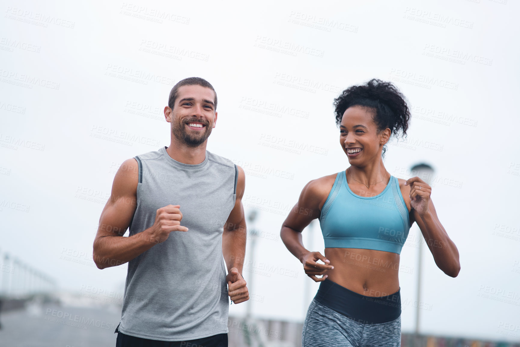 Buy stock photo Shot of two sporty young people exercising together outdoors