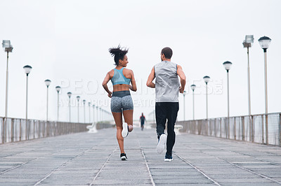 Buy stock photo Rearview shot of two sporty young people exercising together outdoors