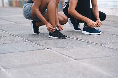 Buy stock photo People, hands and tie shoes for running, fitness or getting ready for workout, hiking or walking in city. Closeup, athletes or runners tying footwear for trekking, health or cardio exercise outdoors