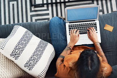 Buy stock photo High angle shot of a young woman using her laptop at home
