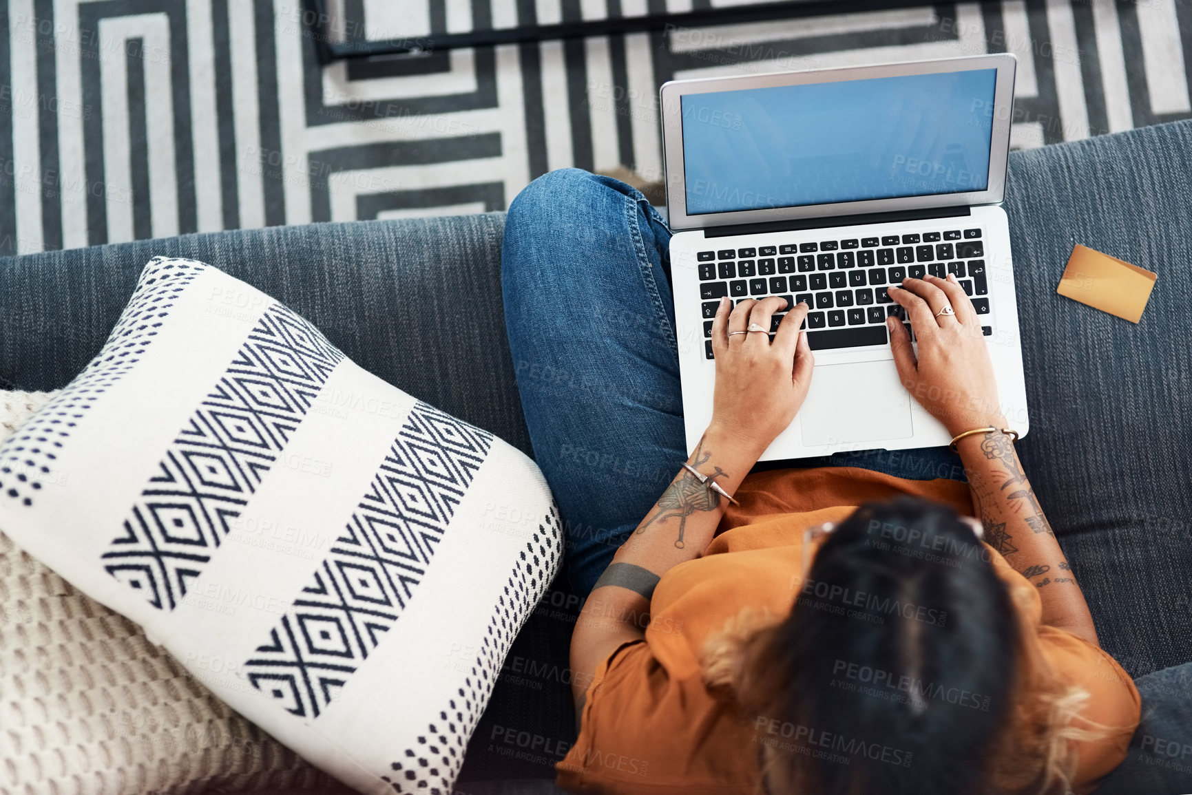 Buy stock photo High angle shot of a young woman using her laptop at home