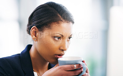 Buy stock photo Shot of a young businesswoman concentrating while using a computer and having coffee in a modern office