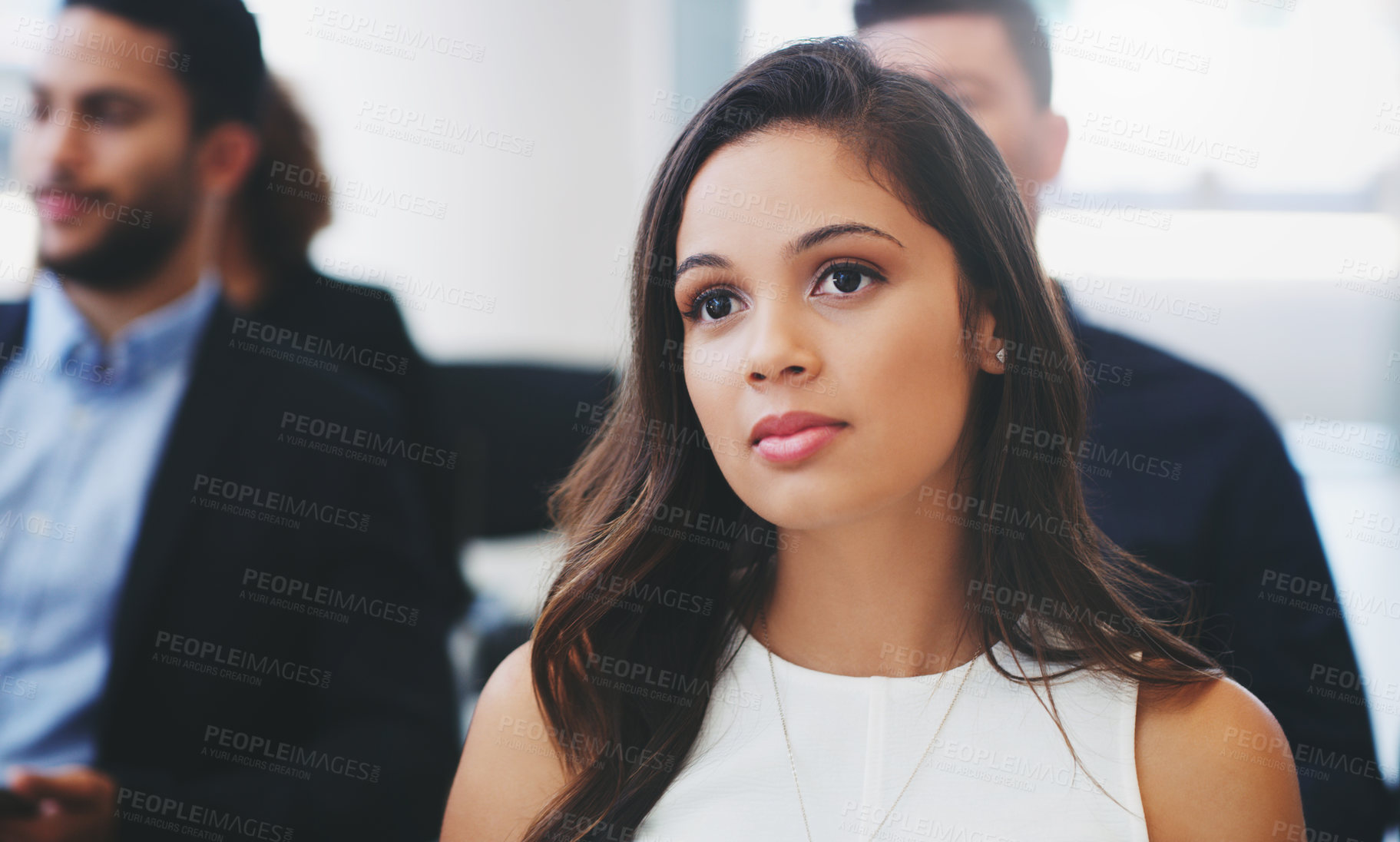 Buy stock photo Shot of a young businesswoman sitting in the audience of a business conference