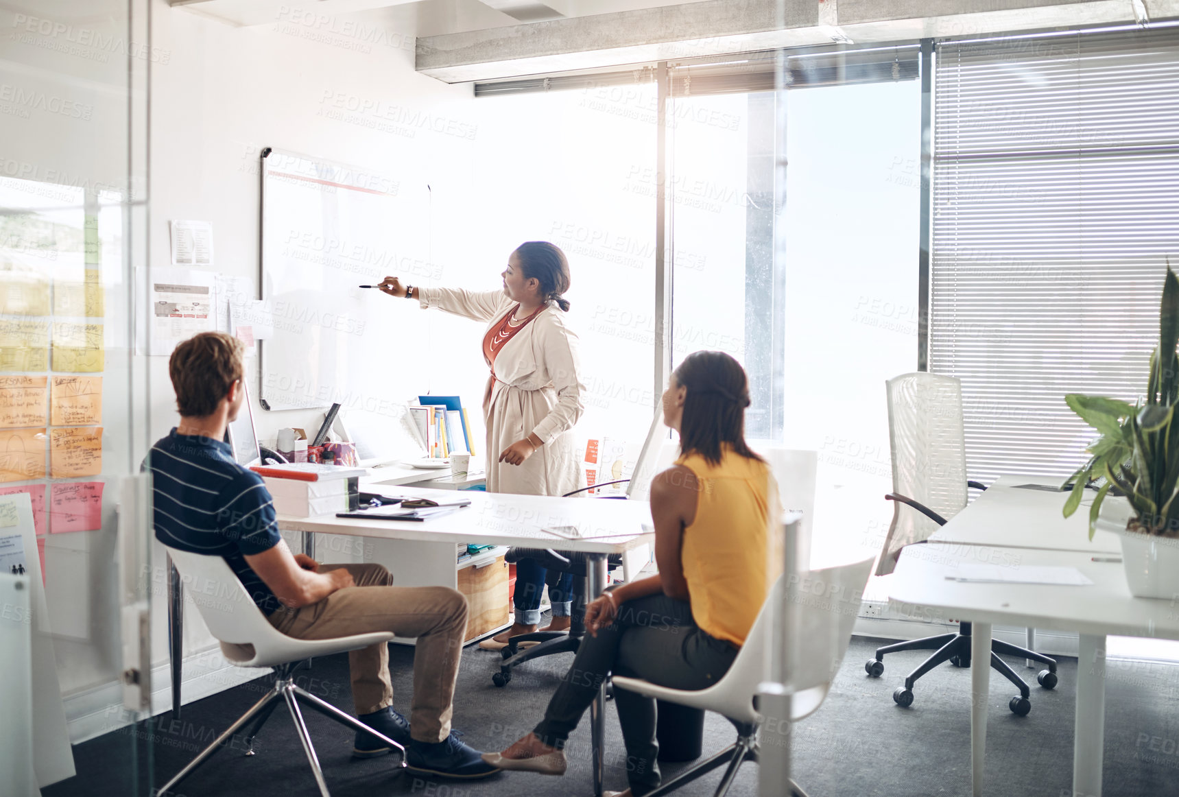 Buy stock photo Full length shot of a diverse group of businesspeople listening to a presentation while sitting in a modern office