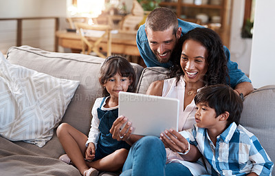 Buy stock photo Shot of a family of four watching something on a digital tablet