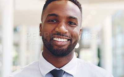 Buy stock photo Cropped headshot of a handsome young businessman standing and smiling at the camera while in the office during the day