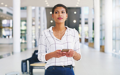 Buy stock photo Cropped shot of an attractive young businesswoman standing alone and using a cellphone while in the office during the day