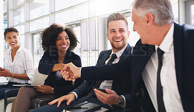 Buy stock photo Cropped shot of an attractive young businesswoman shaking hands with a colleague while sitting in a line in the office
