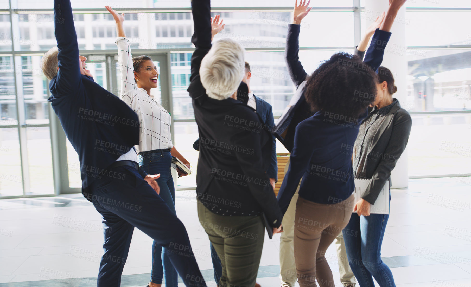 Buy stock photo Cropped shot of a diverse group of businesspeople celebrating and throwing their hands up while in the office