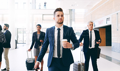 Buy stock photo Cropped shot of three businesspeople walking and pulling suitcases while in the office during the day