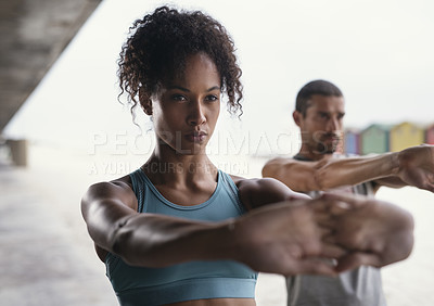 Buy stock photo Shot of a sporty young woman exercising with her boyfriend outdoors