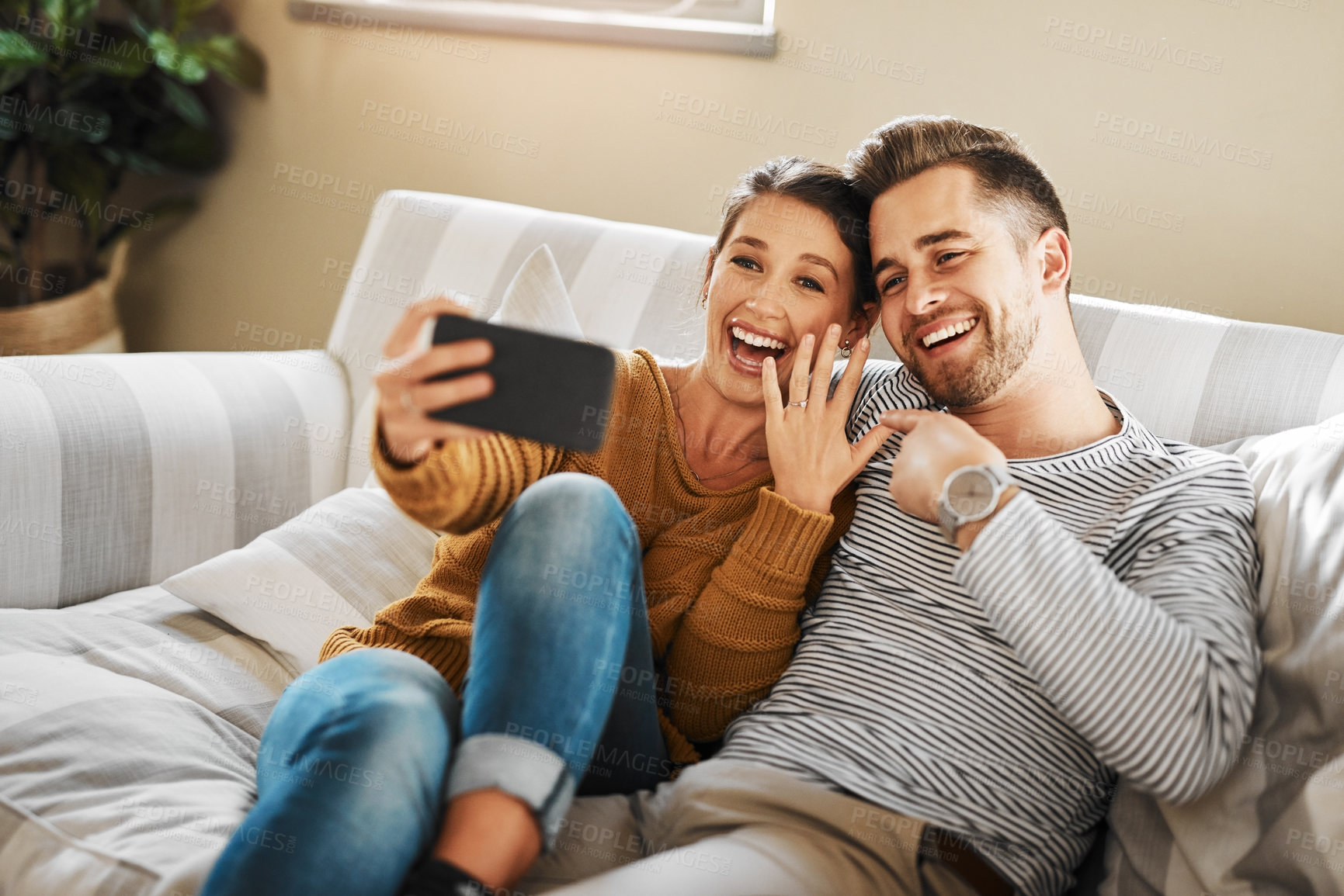 Buy stock photo Shot of a couple announcing their engagement while on a video call
