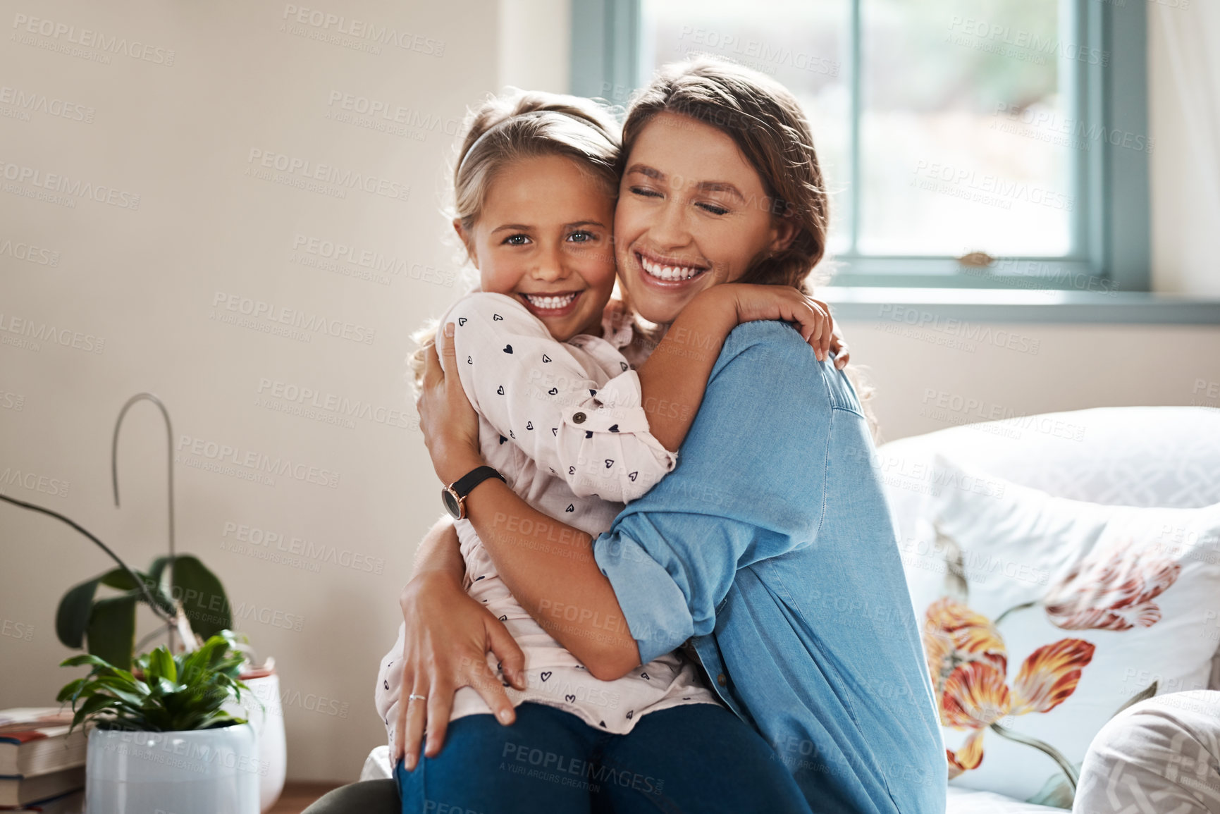Buy stock photo Shot of an adorable little girl hugging her mother at home