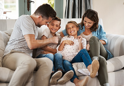 Buy stock photo Shot of a happy young family of four playing together on the sofa at home