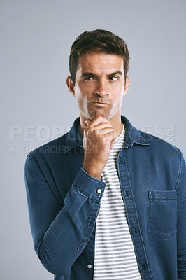 Buy stock photo Cropped shot of a handsome man looking thoughtful against a grey background