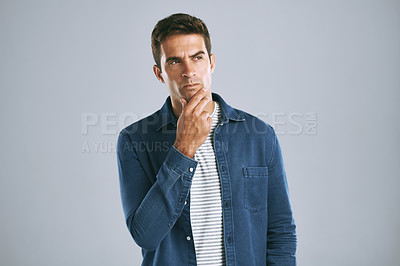 Buy stock photo Cropped shot of a handsome man looking thoughtful against a grey background