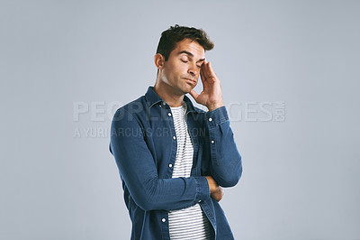 Buy stock photo Cropped shot of a man suffering from a headache against while posing against a grey background