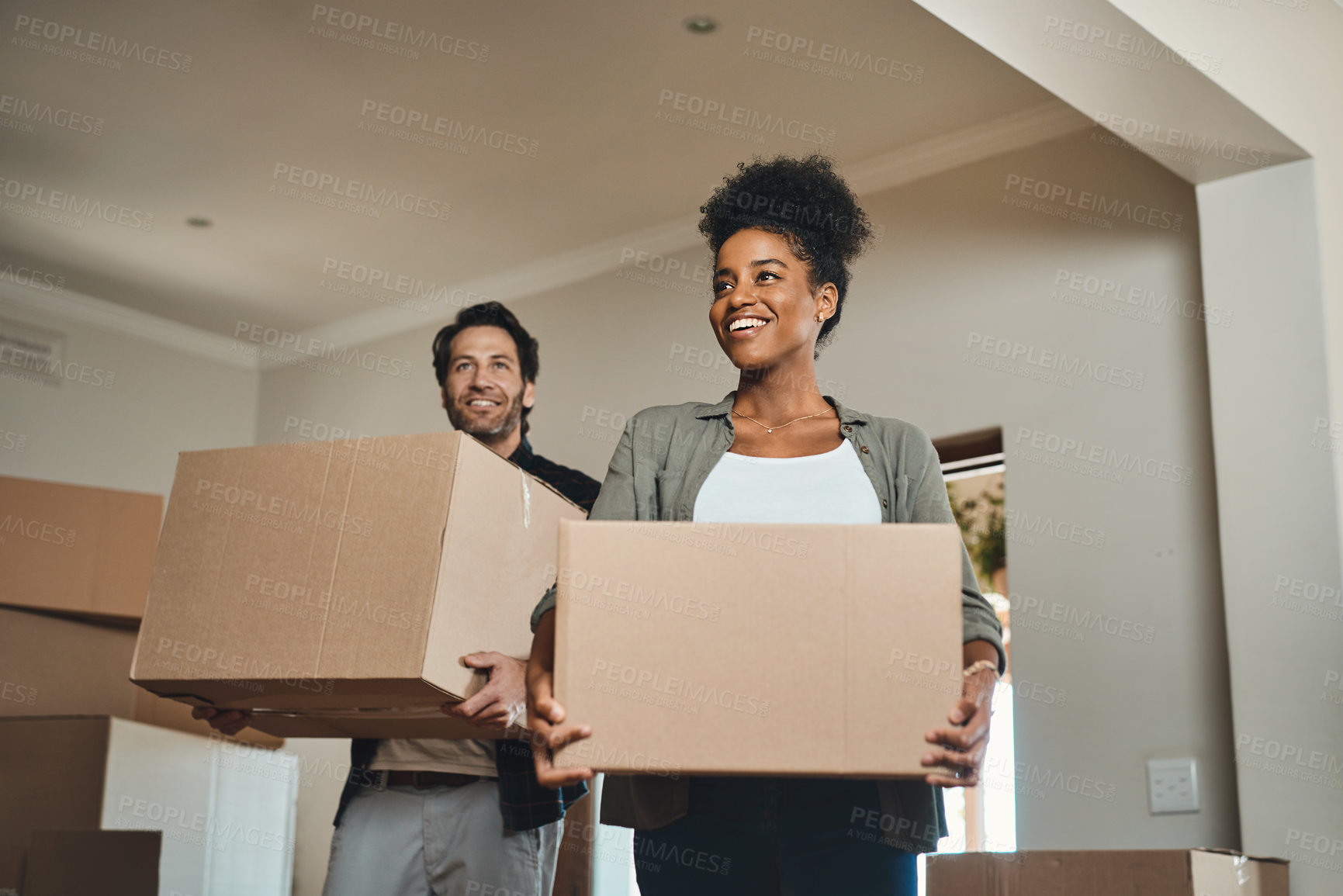 Buy stock photo Happy couple, real estate and moving in with boxes for renovation, investment or relocation in new home. Interracial man and woman realtor owner carrying box in house, move or property loan together