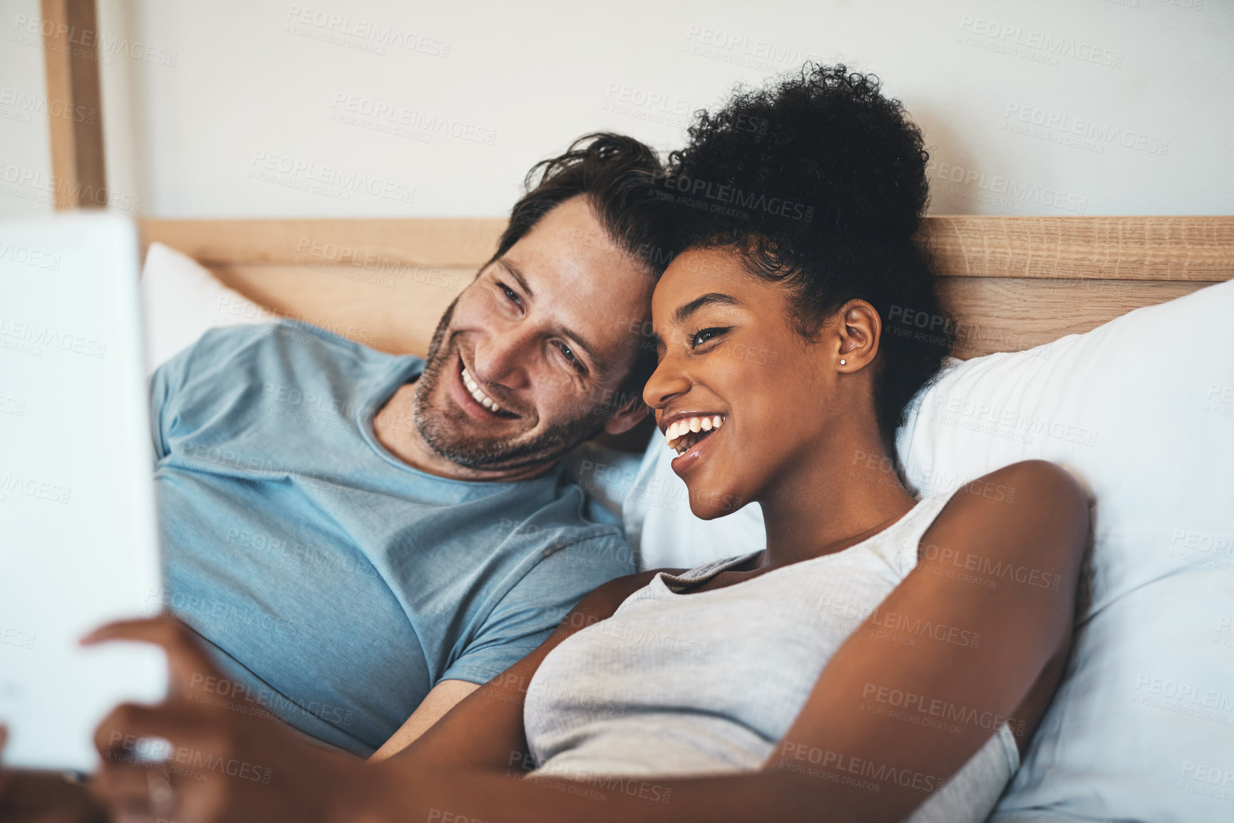Buy stock photo Happy interracial couple, relax and bed for selfie, photo or social media post together at home. Man and woman person with smile for fun profile picture, morning or online vlog in bedroom at a house