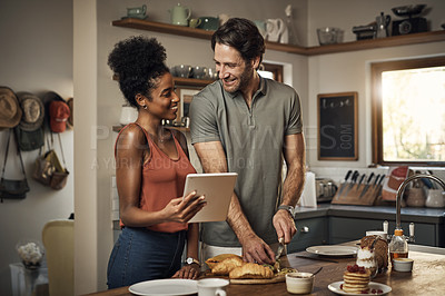 Buy stock photo Interracial couple, tablet and cooking in kitchen for recipe, social media or online food vlog at home. Man and woman preparing breakfast meal or cutting ingredients together with technology on table