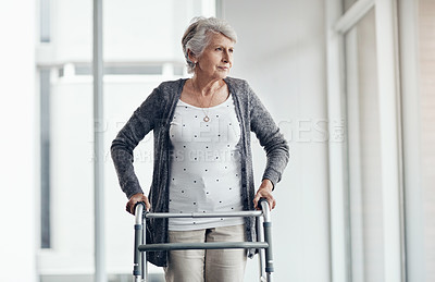 Buy stock photo Shot of a senior woman walking with the assistance of a walker