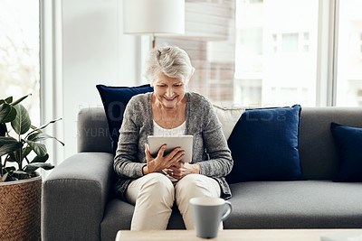 Buy stock photo Senior woman, tablet and home with online, game app or social media scroll for news in retirement. Lounge, sofa and smile with web, tech and relax in living room with soap opera streaming at morning