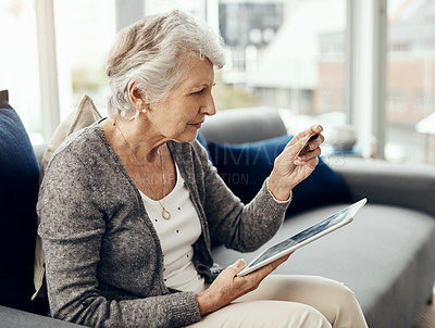 Buy stock photo Shot of a senior woman holding her credit card while browsing on a digital tablet