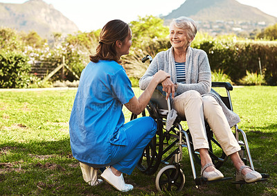 Buy stock photo Cropped shot of a young female nurse outside with a senior patient in a wheelchair