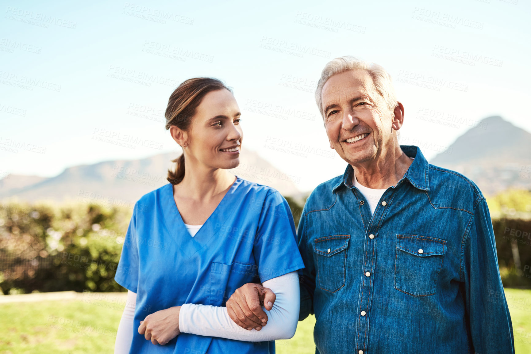 Buy stock photo Cropped shot of a young female nurse outside with a senior patient
