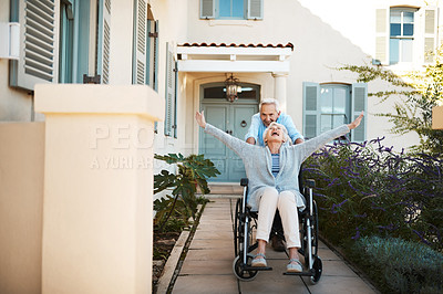 Buy stock photo Full length shot of a cheerful senior man pushing his wife in a wheelchair in their backyard at home