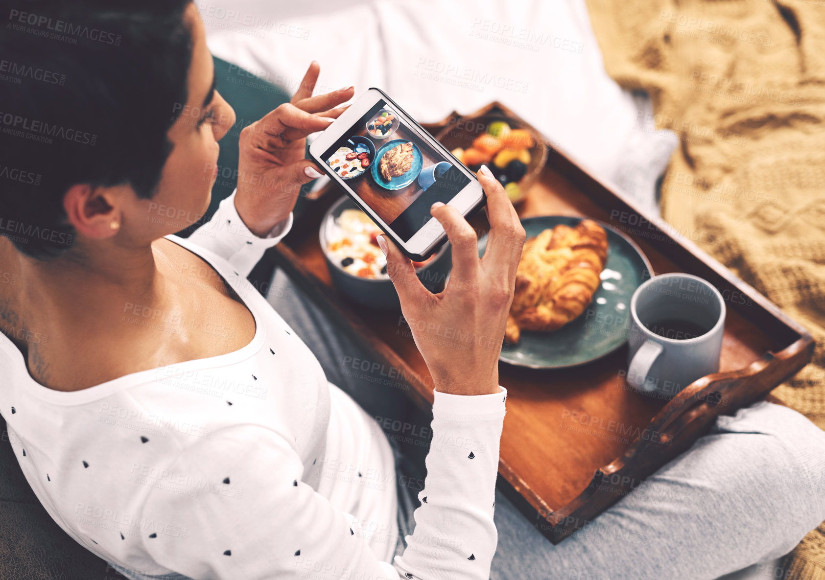 Buy stock photo Cropped shot of an attractive young woman using her cellphone to take a picture of her breakfast tray while at home