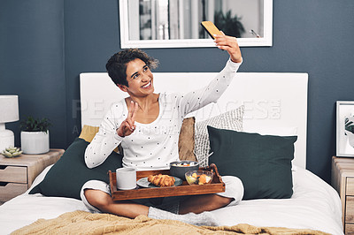 Buy stock photo Full length shot of an attractive young woman taking a selfie while posing with her breakfast tray in bed