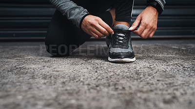 Buy stock photo Cropped shot of an unrecognizable woman crouched down and tying her shoes before running outside