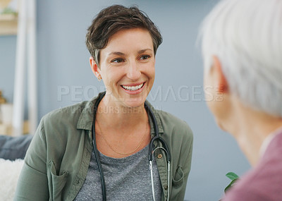 Buy stock photo Cropped shot of an attractive young healthcare professional sitting and talking to her senior patient while in the living room