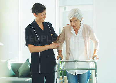 Buy stock photo Cropped shot of an attractive young healthcare professional helping her senior patient walk with a walker in a nursing home
