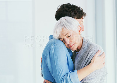 Buy stock photo Cropped shot of an attractive young woman hugging her senior mother closely while at home